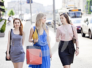 Three beautiful fashion women walking on the street