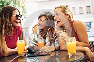 Three beautiful friends in a cafe