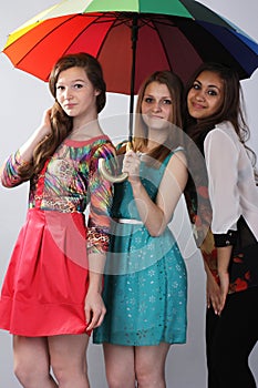 Three beautiful girls, under one umbrella. .