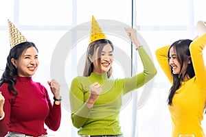 Three beautiful girls wearing party hats are having fun celebrating their birthday