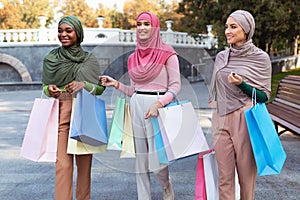 Three Beautiful Muslim Ladies On Shopping Carrying Shopper Bags Outdoors