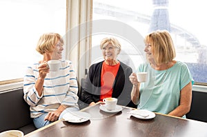 Three beautiful senior women enjoying retirement together having tea or coffee