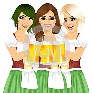 Three beautiful waitresses holding beer mugs for oktoberfest party toasting wearing a dirndl