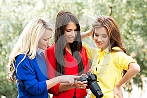 Three beautiful women having a photosession in the park photo