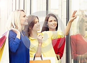 Three beautiful young female shopaholics checking the dress out