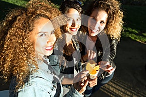 Three beautiful young women visiting eat market in the street.