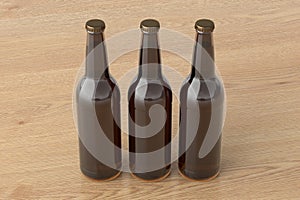 Three beer bottles 500ml mock up on wooden background