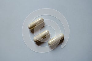 Three beige capsules of Saccharomyces boulardii probiotic from above