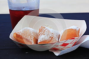 Three Beignet doughnuts in a small tray