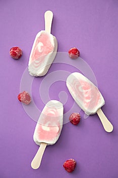 Popsicle with fresh raspberry on a table