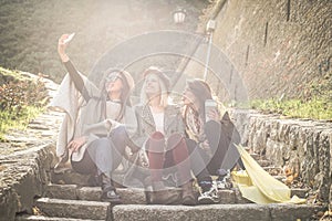 Three young girls sitting on the stairs at the public park.