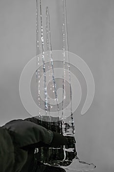 Three big icicles in a gloved hand