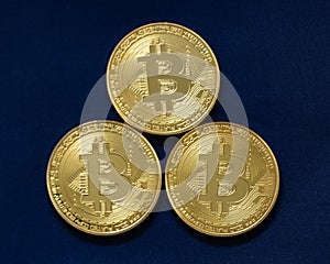 Three bitcoins isolated on blue