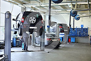 Three black cars stand in small service station and two men