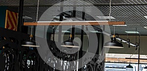 Three black decorative lamps hang from the ceiling of the cafe