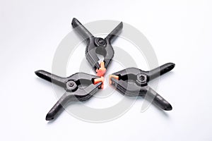 Three black plastic spring clamps arranged differently