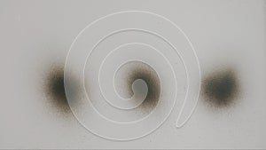 Three Black Spray Paint Dots on White Background