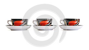 Three black tea cups with saucers isolated
