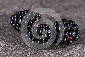 Three blackberries on gray stone