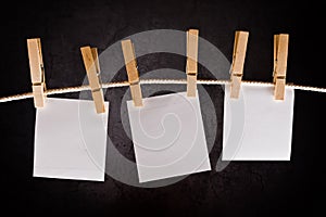 Three Blank paper notes hanging on rope with clothes pins