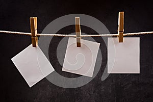 Three Blank paper notes hanging on rope with clothes pins