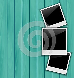 Three blank photo frames on wooden background