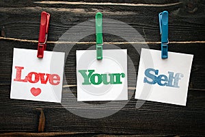 Love your self in squre paper notes hanging by clothespin