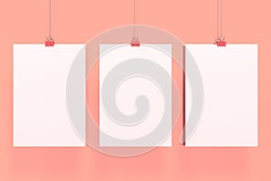 Three blank white posters with binder clip mockup on red background