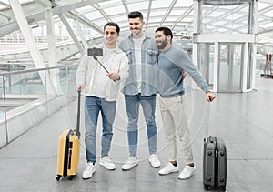 Three Bloggers Men With Suitcases Making Selfie In Modern Airport