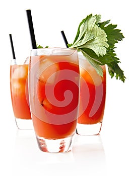 Three Bloody Mary with ice cubes with celery isolated on white