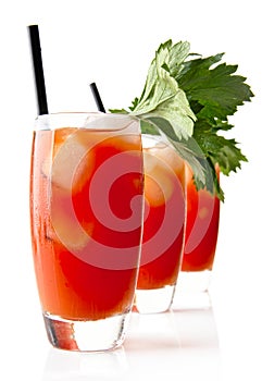 Three Bloody Mary with ice cubes with celery isolated on white