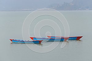Three blue boats on Phewa Lake in Pokhara