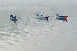 Three blue boats on Phewa Lake in Pokhara