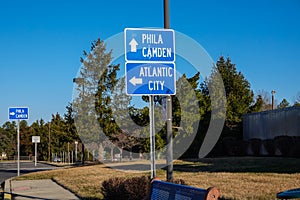 Three blue direction signs with arrows pointing directions to Atlantic City, Philadelphia and Camden.