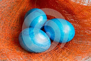 Three Blue Easter eggs on orange background