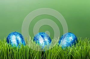 Three blue foil Easter eggs on grass