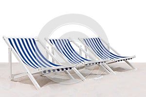 Three blue and white striped beach chair on the sand beach isolated on white background