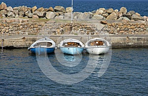 Three boats at bay with stone pier