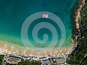 Three boats stand on the shore. Beach with umbrellas and sunbathers. Summer Beach Prainhas do Pontal de Atalaia in