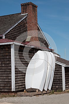 Three boats and a weathered, shingled house