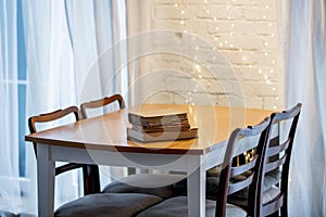 Three boooks on a table in a kitchen.