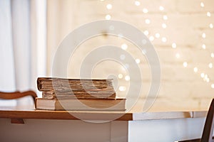 Three boooks on a table in a kitchen.