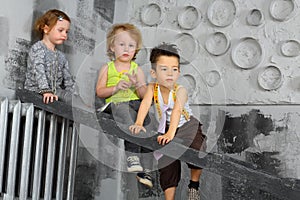 Three bored children sitting on the stairs