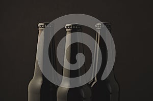 Three bottle of beer on a dark background/Three bottle of beer on a dark background, selective focus