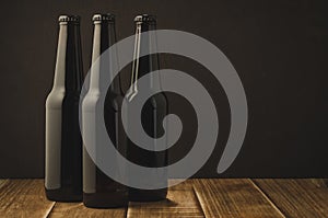 Three bottle of beer on a dark background/ Three bottle of beer on a dark background, selective focus and copyspace