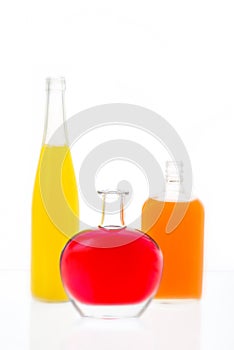 Three bottles with alcohol on a table with the reflecting surfa