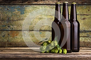Three bottles of beer against wooden background