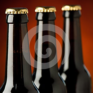 Three bottles of beer over brown background.