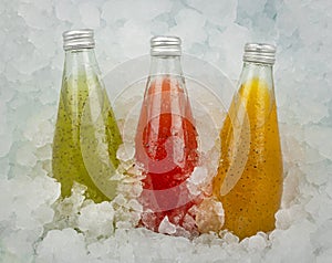 Three bottles of fruit juice drinks on ice