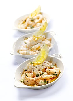 Three bowls with prawns and garlic butter